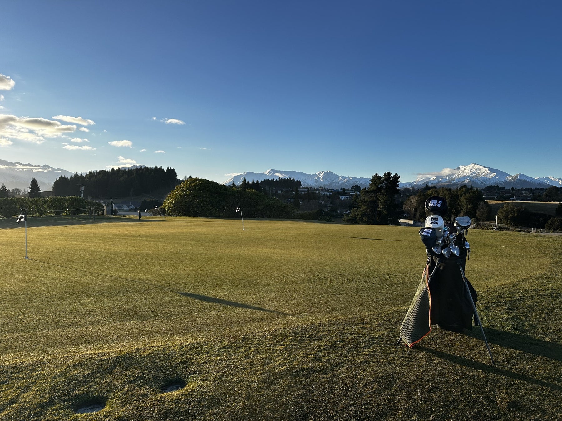 Evening light across a golf green with mountains beyond